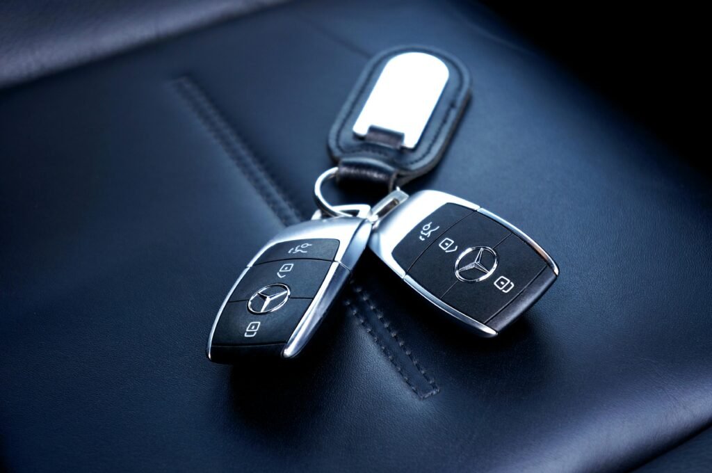 pexels-photo-13101559-13101559 Two Mercedes Benz car keys resting on a luxurious leather seat, showcasing elegance and design.